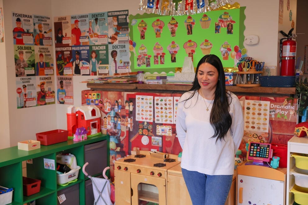woman stands next to colorful posters