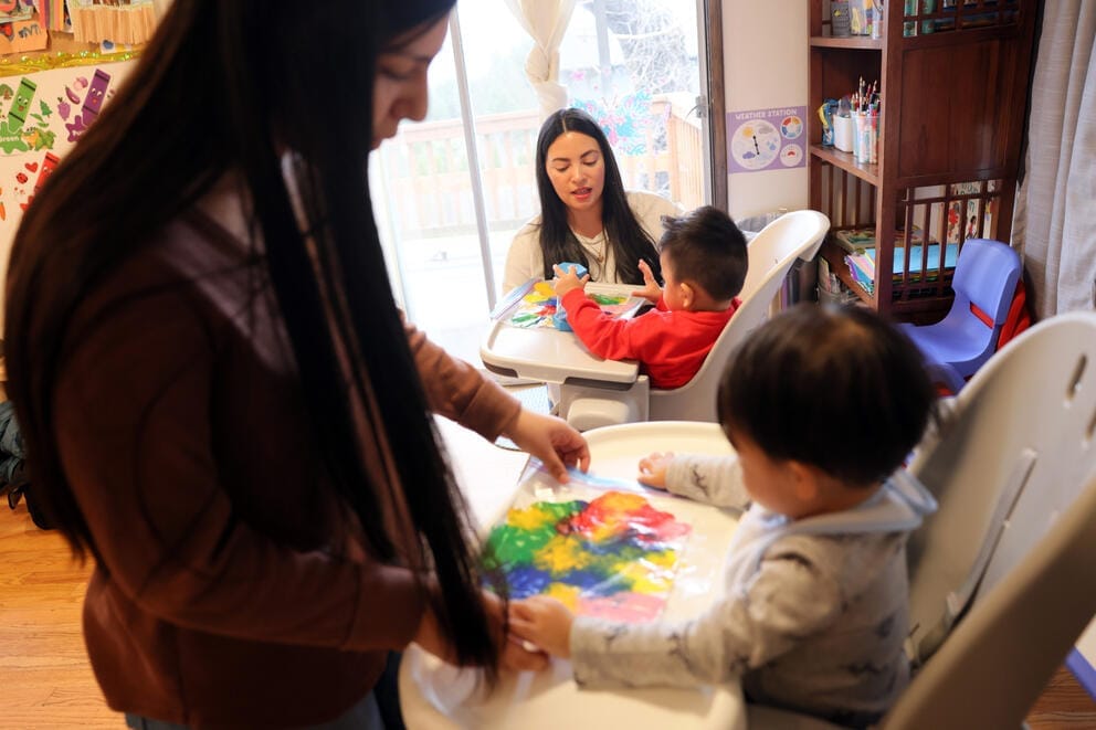 toddlers sit in high chairs and finger paint