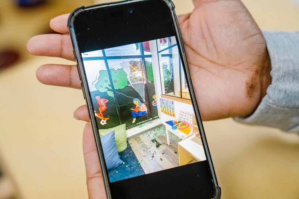 a woman's hand holds a cell phone with a photo on it