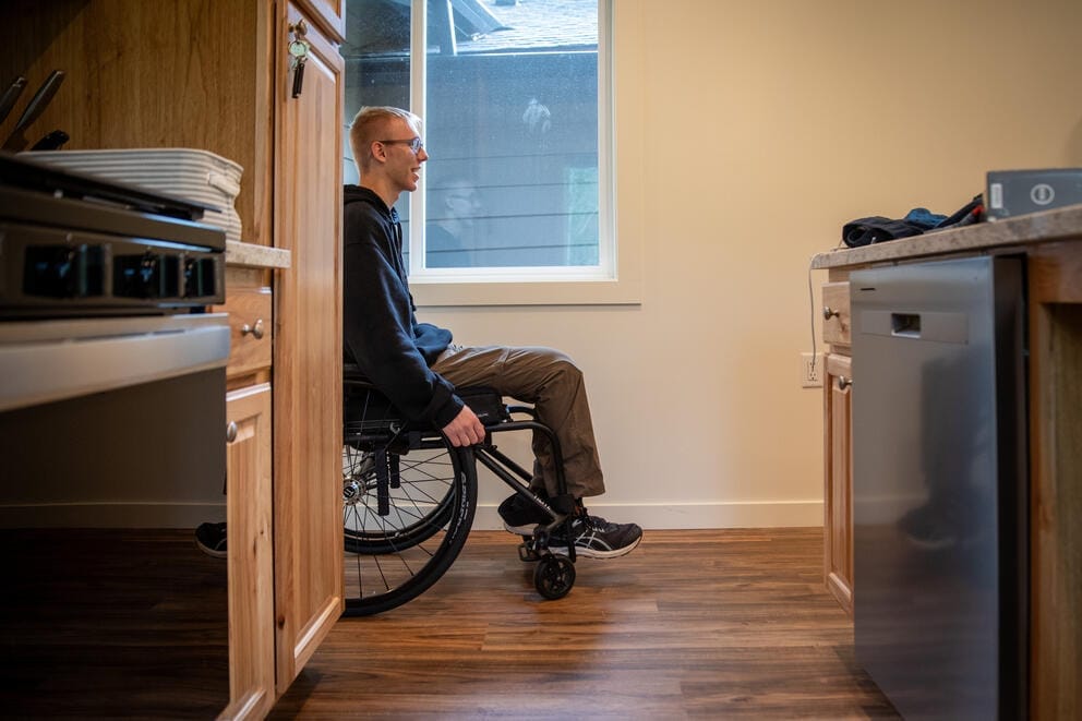 Derrik rolls through the tiny home behind his parents' house.