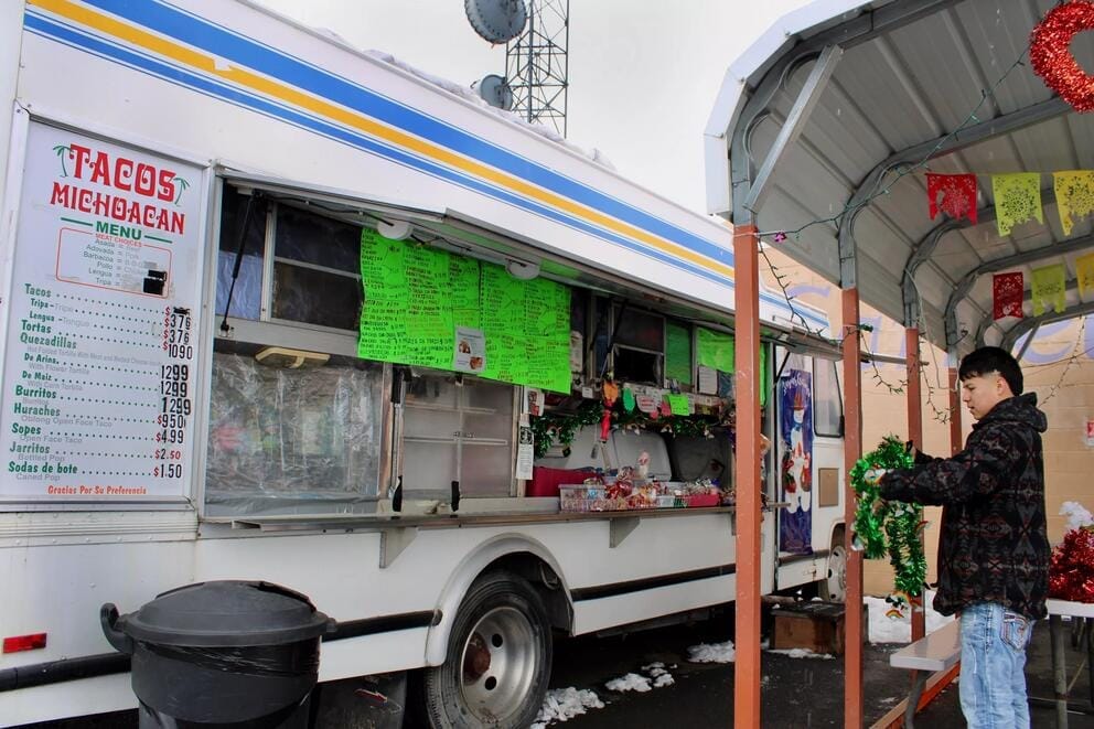 A person puts decorations on a food truck.