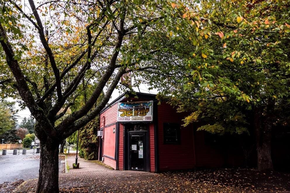 A building near a tree with a sign outside that says