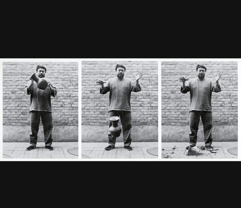 Three black-and-white photos in a row of artist Ai Weiwei dropping an antique vase