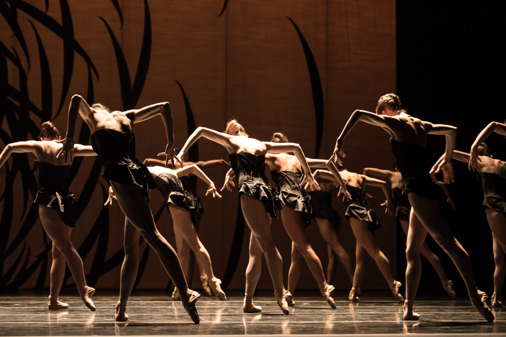 photo of a dance company performing on a dark stage