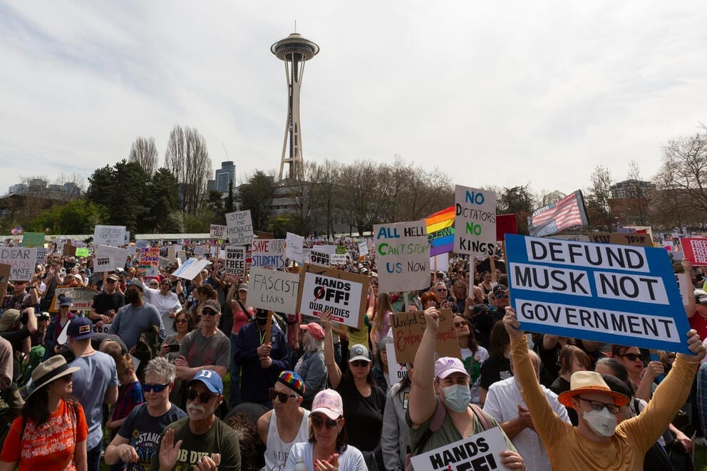 A crowd of protestors with the Space Needle in the background