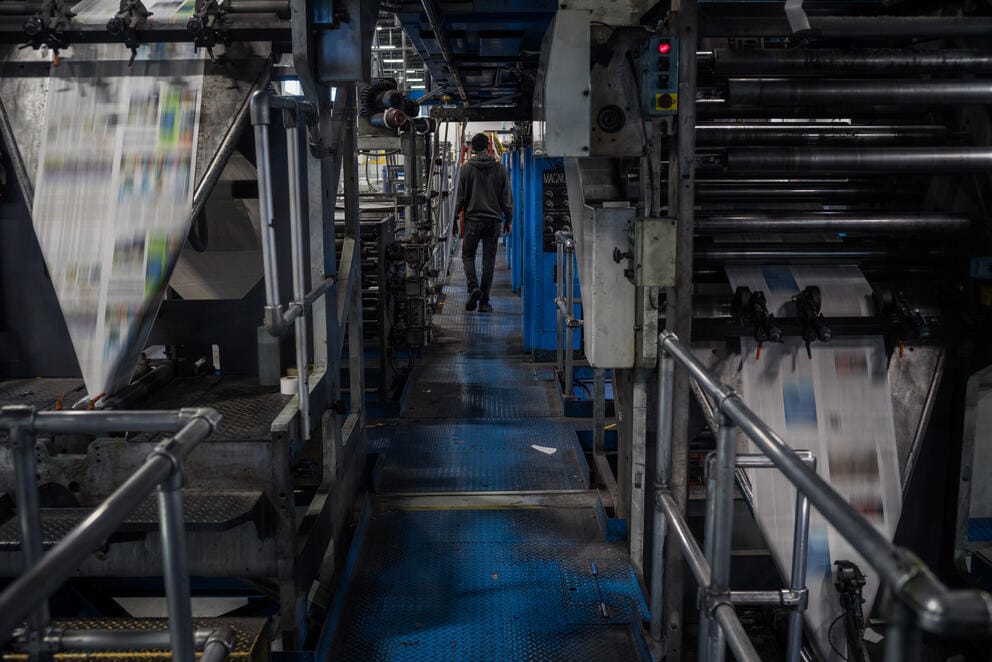 A pressman walks past the newspaper press