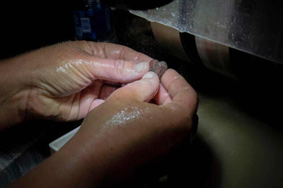 close up shot of hands carving a stone heart