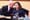 a man leans in to speak to a woman sitting behind the city council chambers desk in Seattle