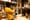 A man in a yellow sweatshirt plays a flugelhorn in bookshop while a standing crowd watches and listens.