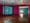 Two pink and turquoise walled gallery rooms with intricately carved installations that case shadows all over the walls.