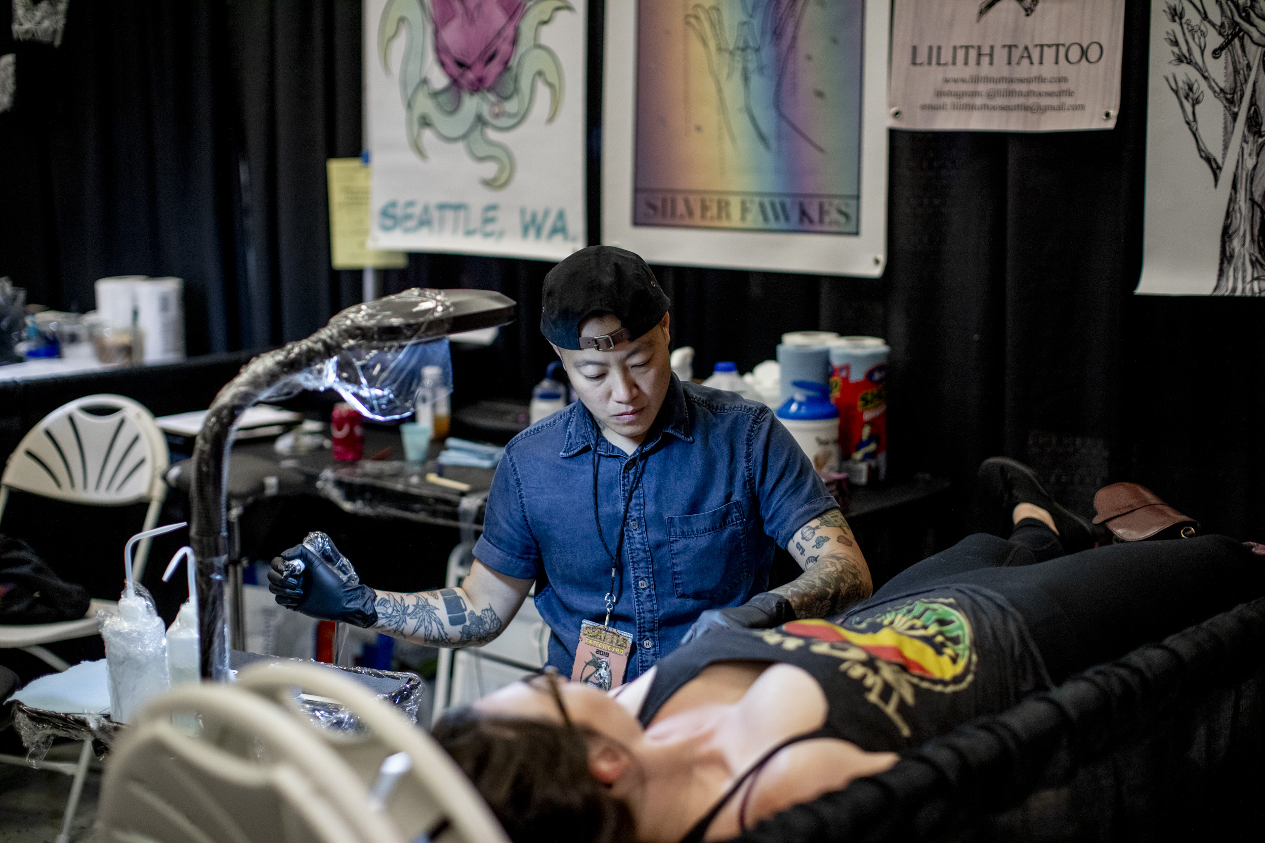 Owner of Lilith Tattoo shop in Fremont Jude Vesvarut tattoos Emily Hueter during the Seattle Tattoo Expo in the Seattle Center on Aug. 16, 2019.