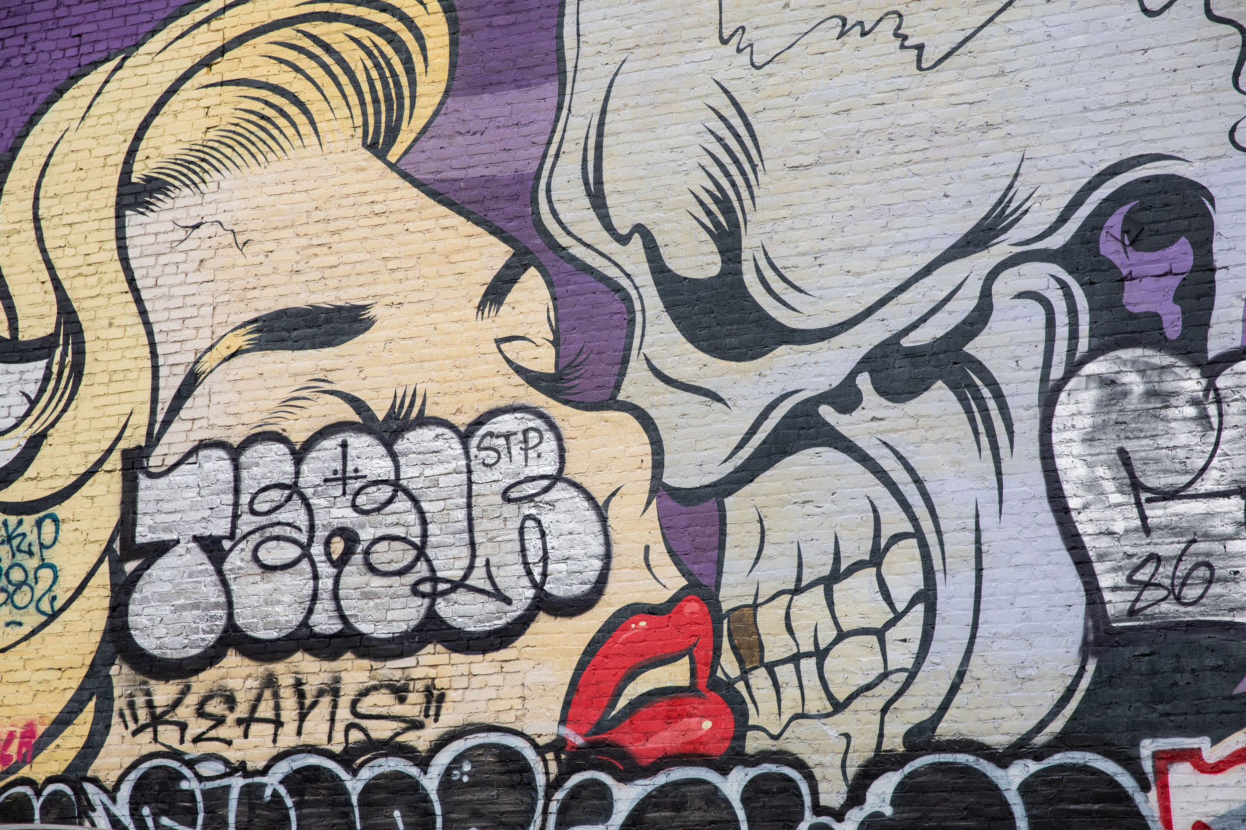 Tags cover a mural of a woman and a skeleton figure