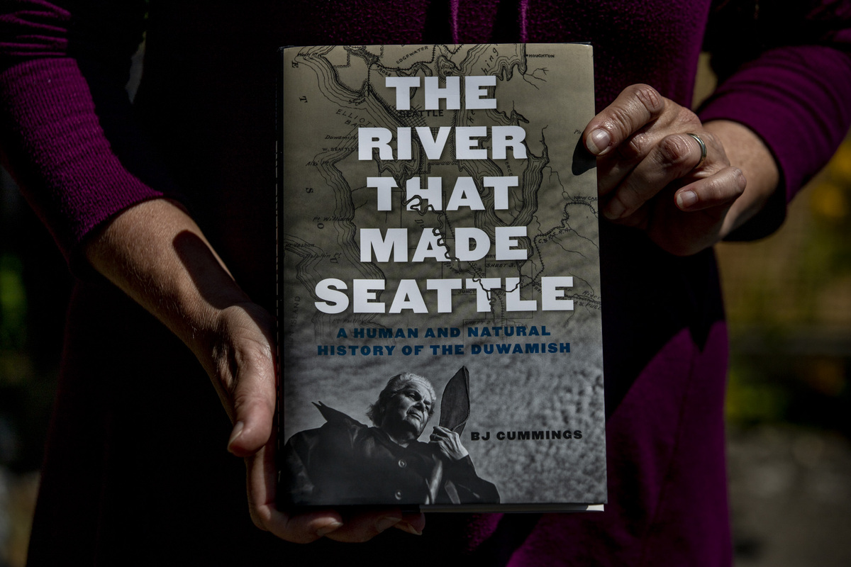 Author BJ Cummings holds a copy of her book, 'The River That Made Seattle,' on June 25, 2020.