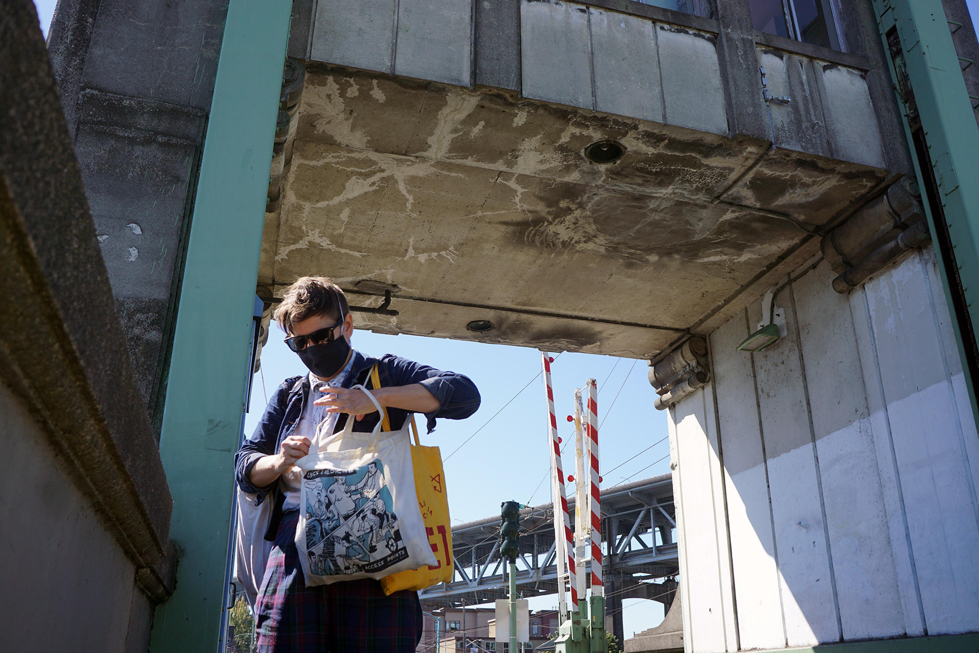 E.T. Russian looks through bag while under the bridge tower outside