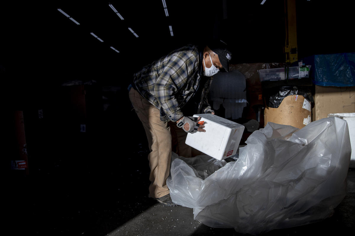 a man amid boxes sorts Styrofoam