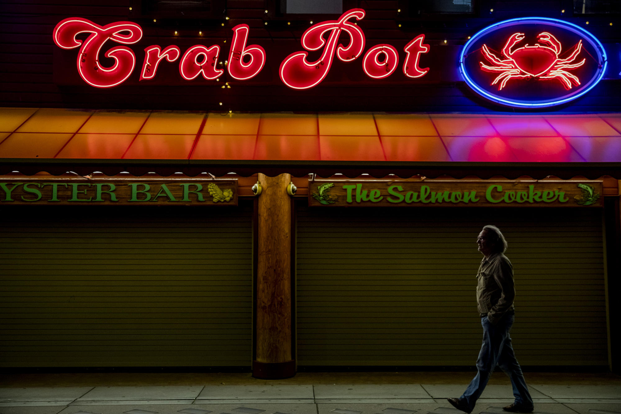 Man walks under neon sign