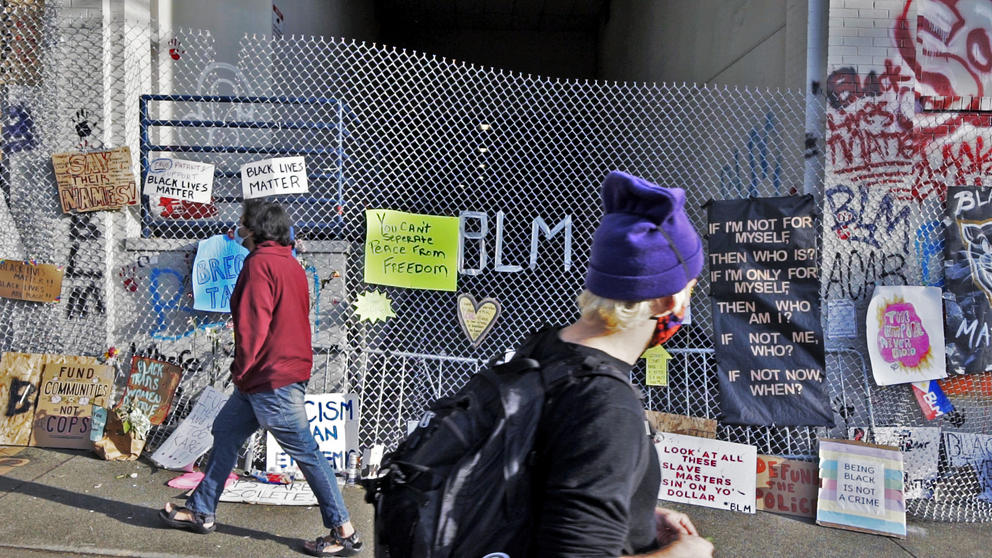 People walking by protest signs
