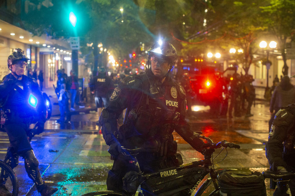 Police officer with bike, with other officers behind him