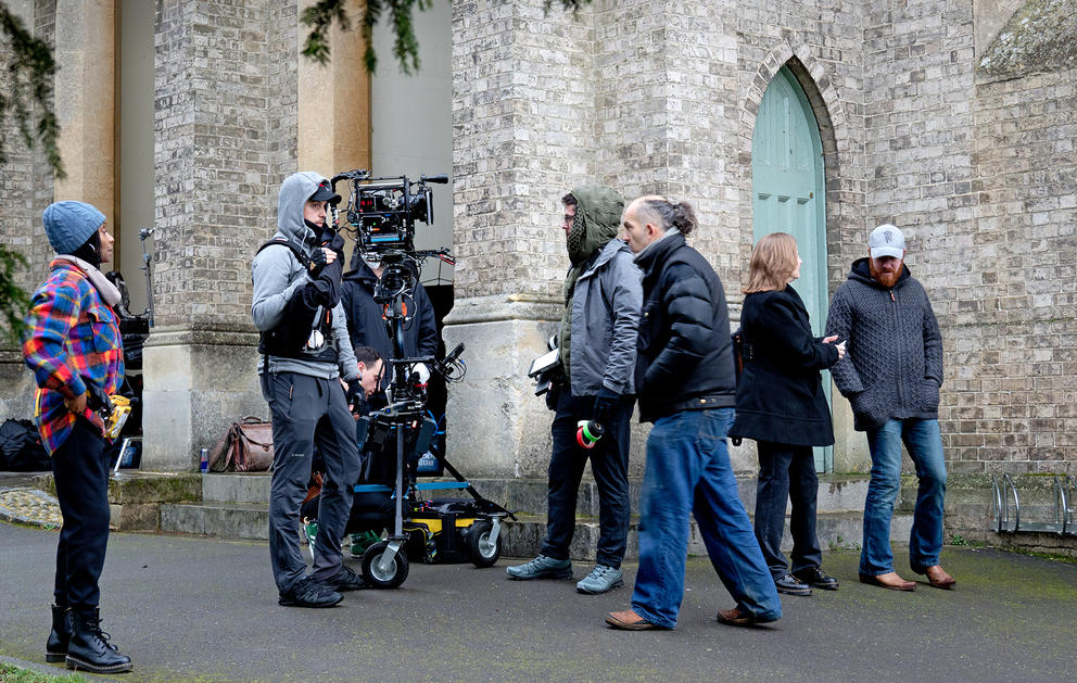 A group of people on set to film a movie outdoor