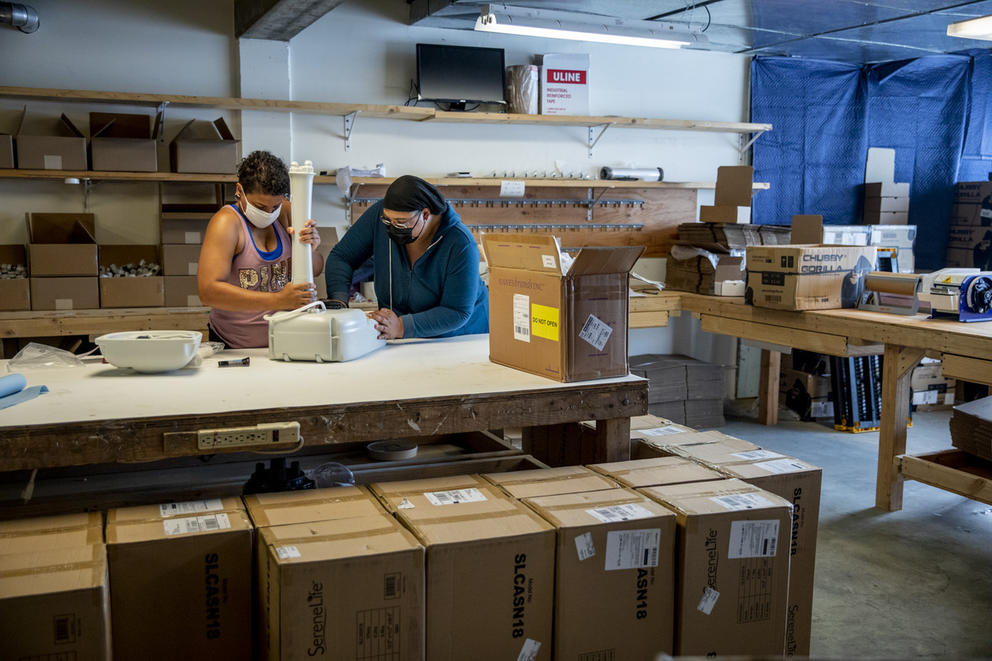 Two people working on a sink in a warehouse