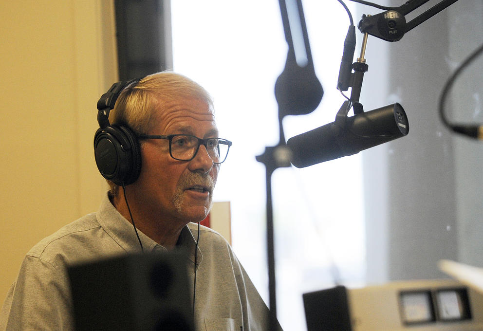 William Armacost in headphones in front of a microphone