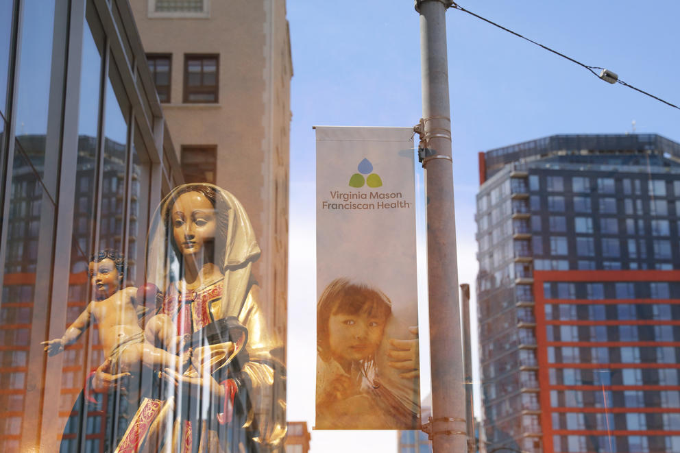Statue of the Madonna and Child, and a Virginia Mason ad of a toddler with their ear to their mother's pregnant belly