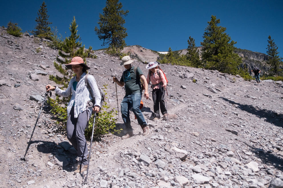 Three people hiking down a slope