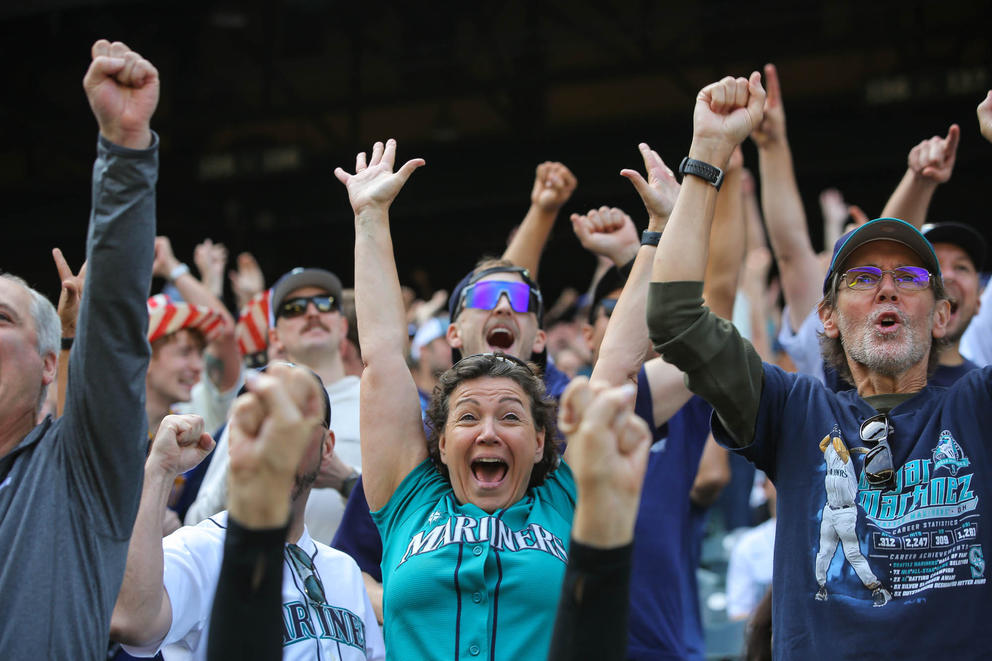 Fans cheer with their arms raised