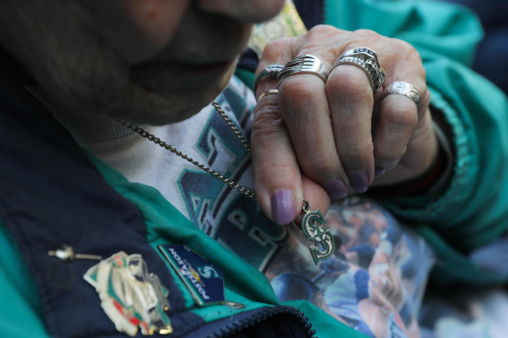 A close up of a woman holding up her necklace