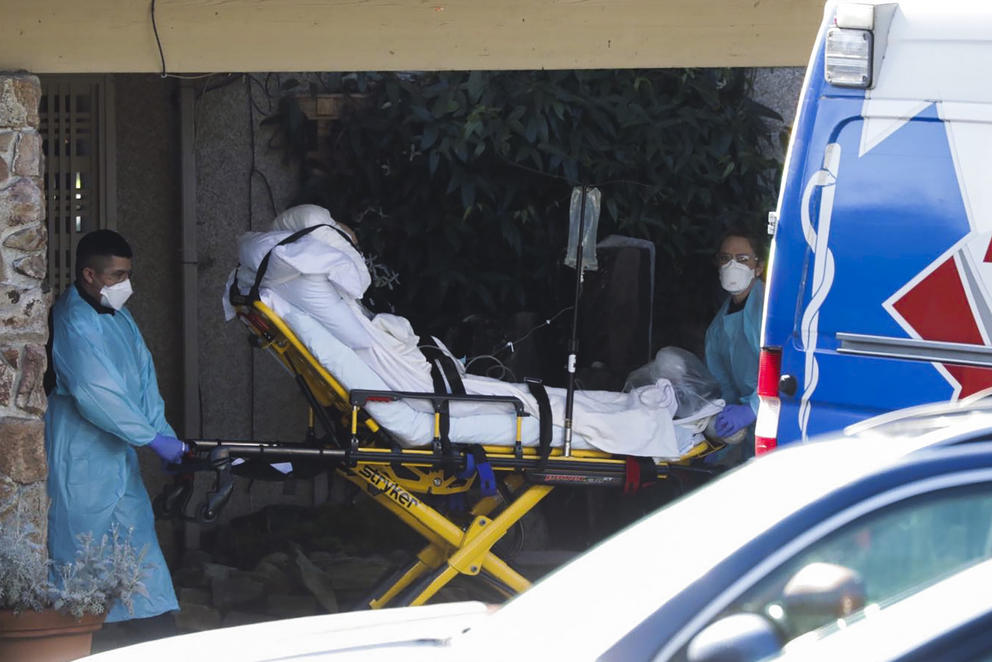 person on a stretcher in front of an ambulance