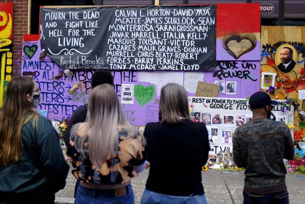 People stand before a memorial