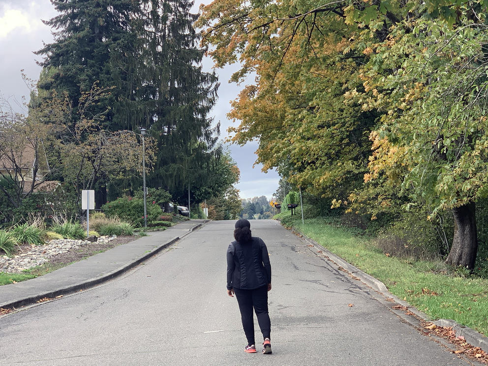 woman walking on street in fall foliage