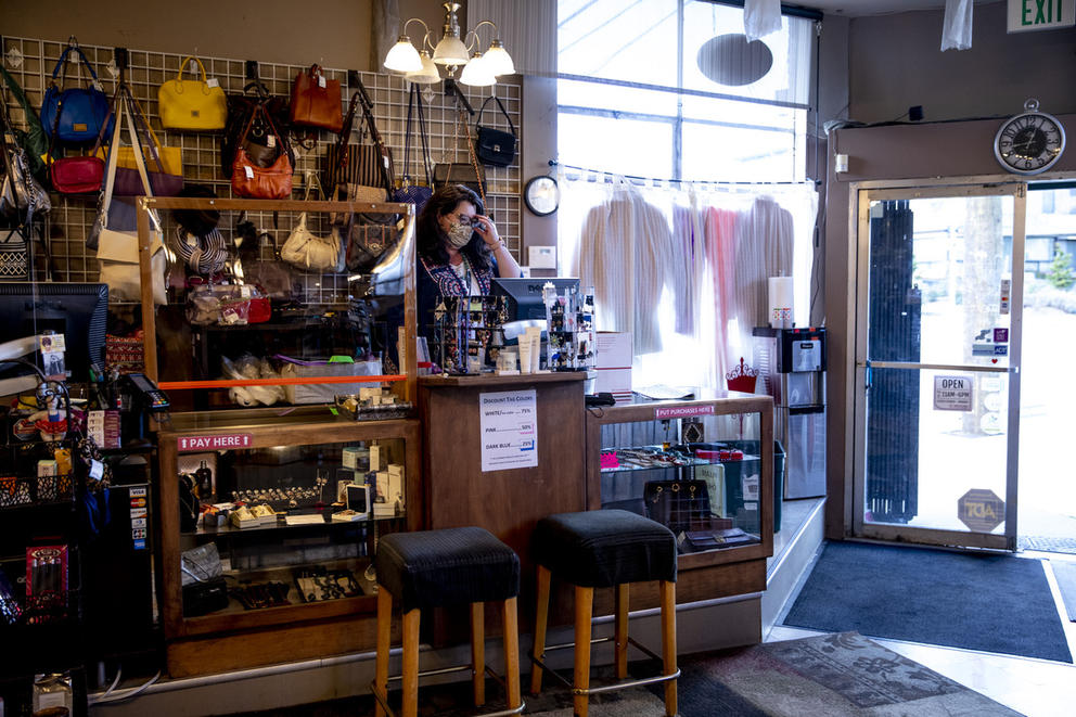 Lisa Michaud stands behind the cash register, surrounded by purses
