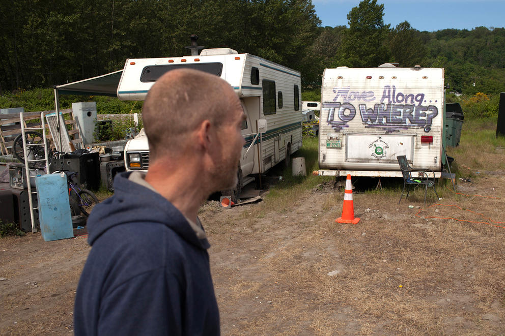 a man in front of an abandoned RV