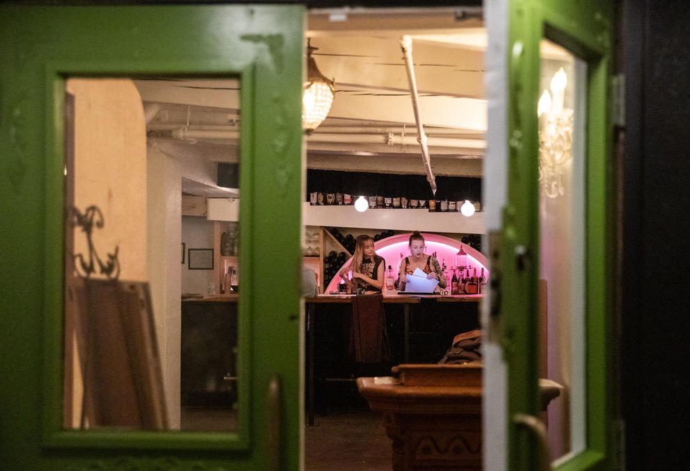 A green door is open to the Rabbit Hole, showing two workers behind a counter. 