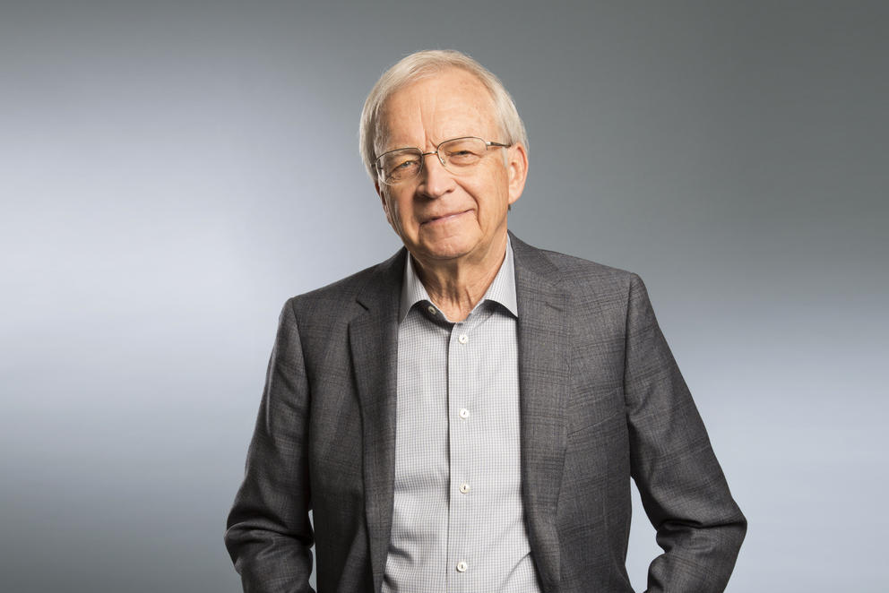 Tom Alberg poses in front of a grey and black background 