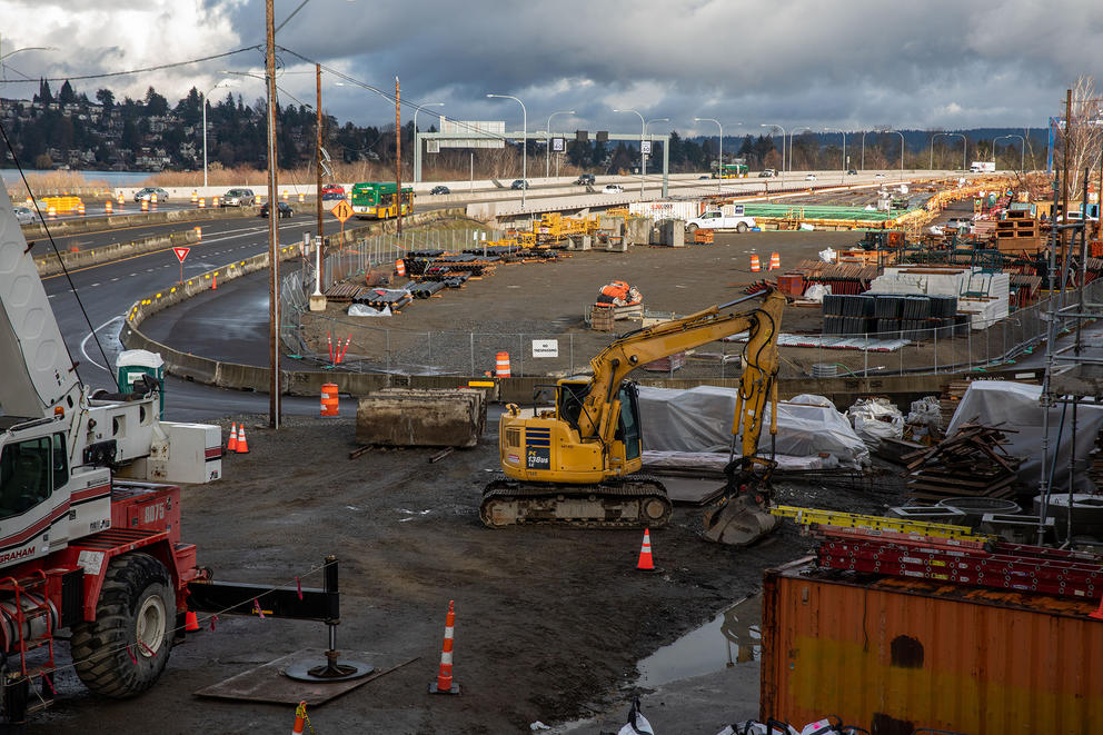 A muddy active construction site near a highway