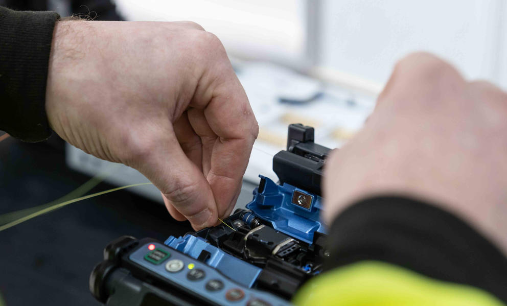 A close look at David Elias' hands as he connects fiber cable. 