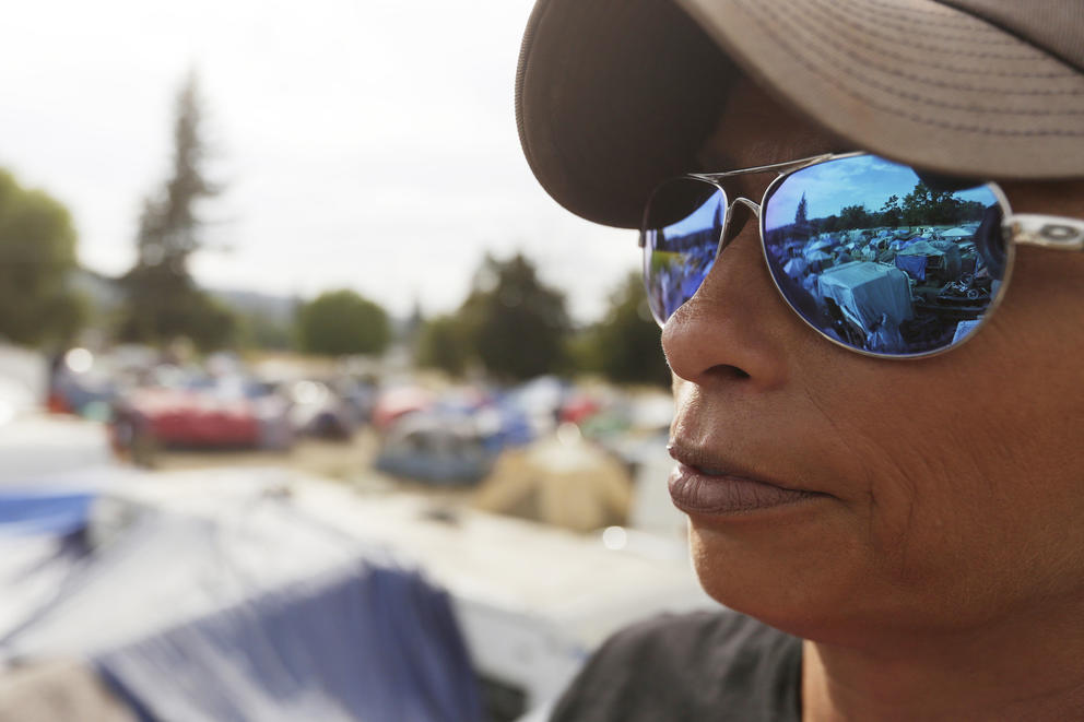 Camp Hope encampment reflected in a woman's sunglasses