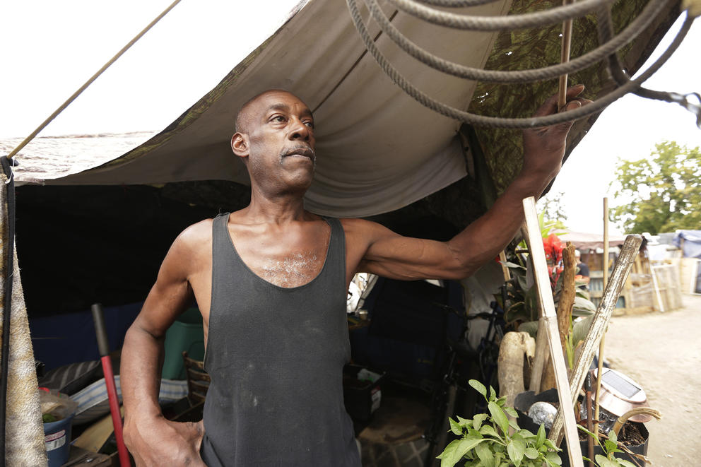 A man in front of his tent at the Camp Hope encampment 