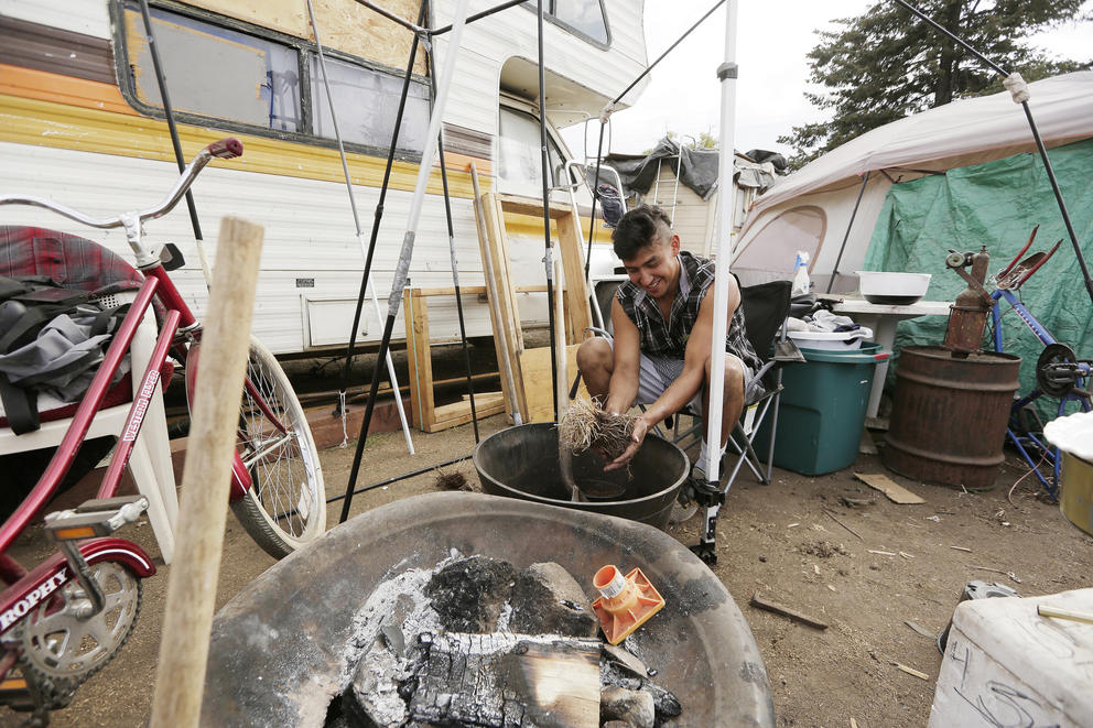A man making compost at the Camp Hope encampment 
