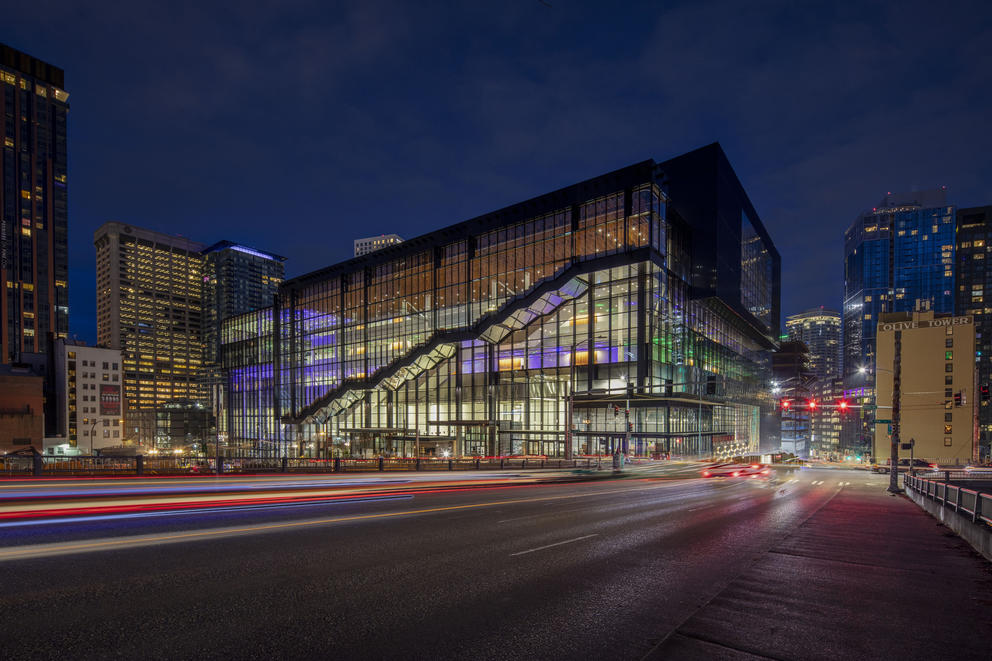 Night-time photo of the convention center building, lights from cars become streaking lights in the dark