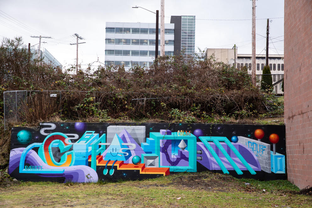 A mural covers a low outdoor wall