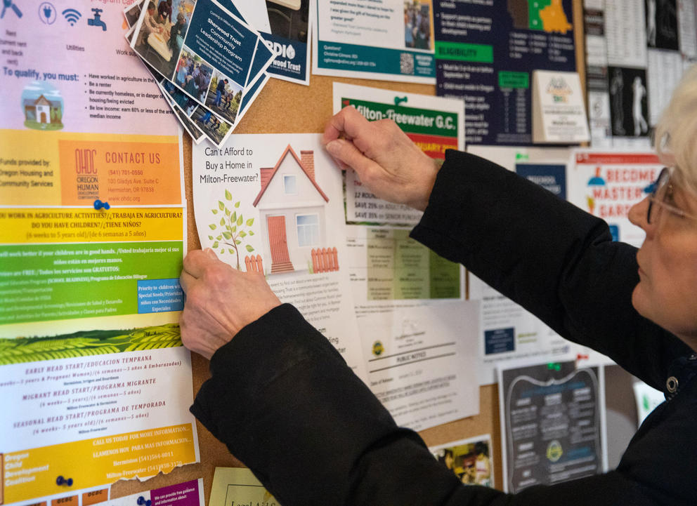 Trish puts up fliers for a community event
