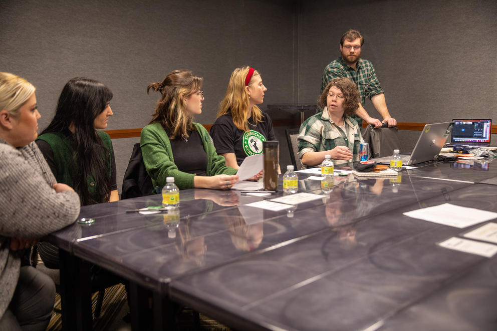 Six union bargaining team members sit on one side of a long gray conference table.
