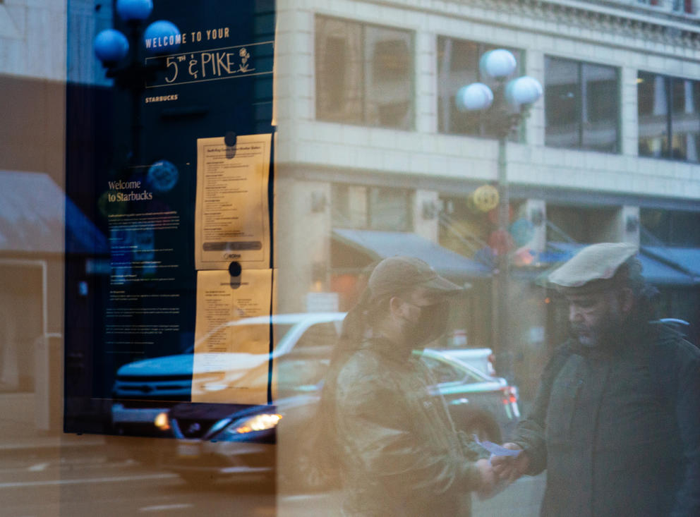 A Starbucks employee is reflected in a window as they hand out pro-union fliers.