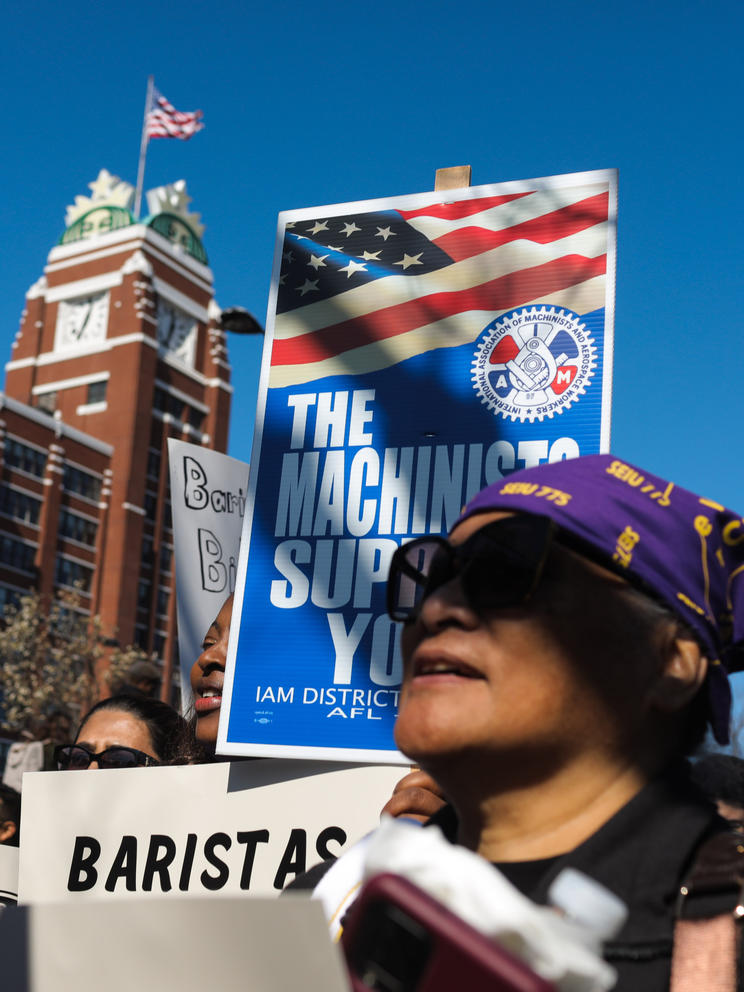 people hold signs in front of Starbucks headquarters