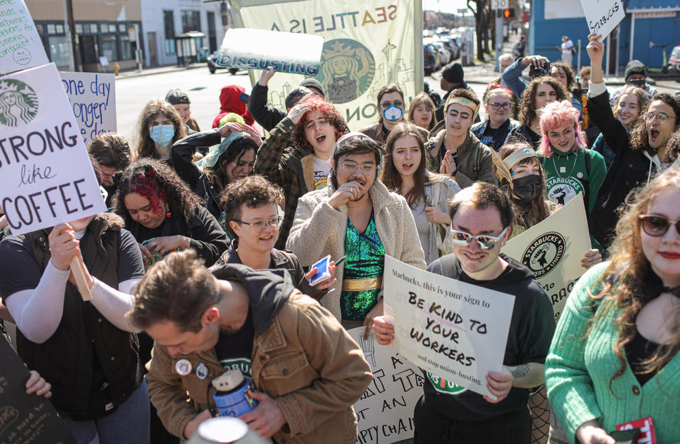 A group of protesters hold signs outside
