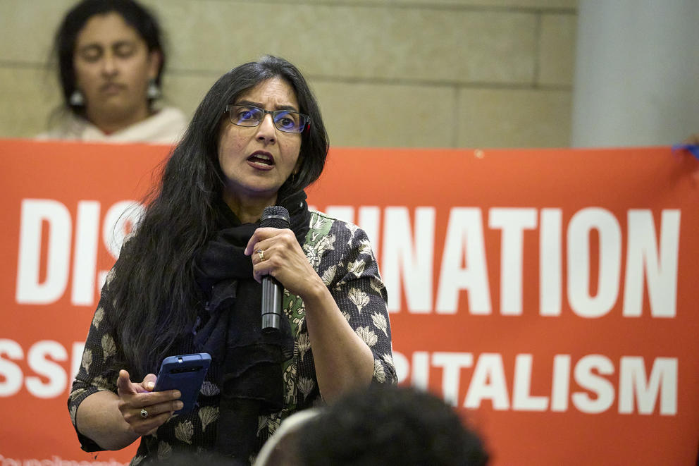 Seattle Council Member Kshama Sawant speaks into microphone