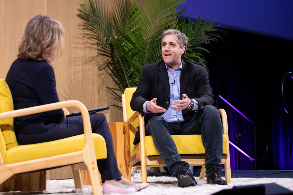 Two people sitting on stage, talking